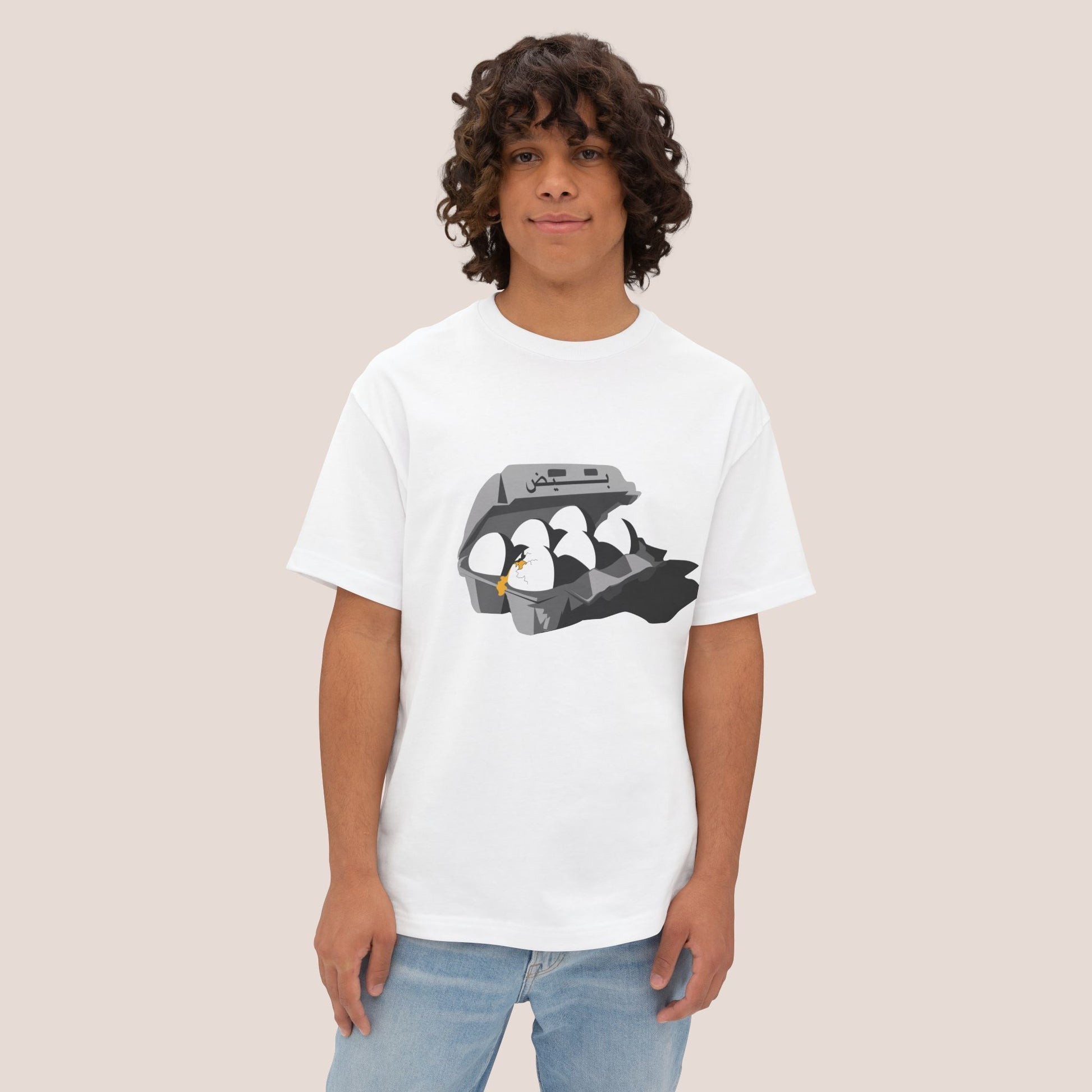 Person wearing a white t-shirt with a graphic design on a plain background